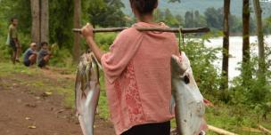 Woman carrying fish - Photo by:  Thome Xaisongkham, Oxfam in Laos