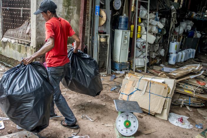 Man carrying away garbage, Vientiane, Laos Man carrying away garbage, Vientiane, Laos