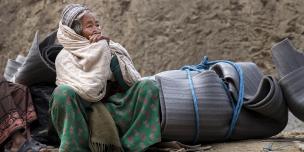 An elderly earthquake survivor waits for transport after receiving a Winterisation Kit - Credit: Kieran Doherty/Oxfam