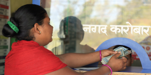 A woman takes out the money send by her husband from India - Credit: Oxfam/OIM/UNDP A woman takes out the money send by her husband from India - Credit: Oxfam/OIM/UNDP