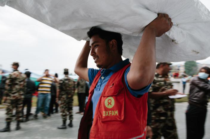 Oxfam volunteer Shekhar Khadka (23) works to off load latrines being delivered to the Tundikhel IDP camp in Kathmandu, Nepal. He is one of 500 volunteers trained to react in the event of an earthquake during the urban risk management program - Credit: Aubrey Wade/Oxfam