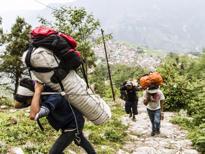 Porters carry relief goods up to remote Laprak village in Gorkha district - Credit: Sam Pickett/Oxfam