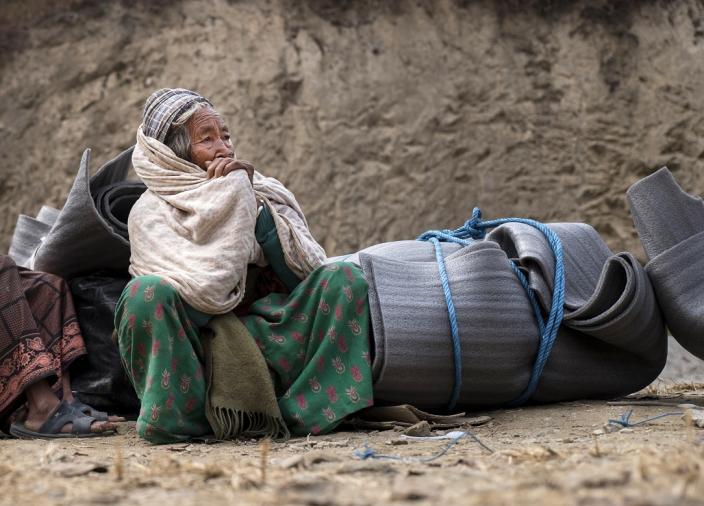 An elderly earthquake survivor waits for transport after receiving a Winterisation Kit - Credit: Kieran Doherty/Oxfam