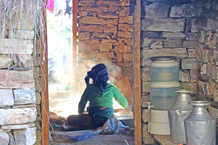 A woman in Kerauja sifting grains in traditional way. 