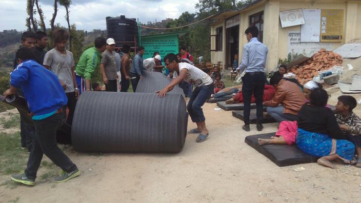 Staff trained in disaster preparedness roll out thermal mats to provide space for the treatment of many injured just an hour after the devastating earthquake - Credit: DRR Team/Oxfam