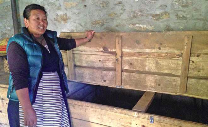 Furafutti Sherpa showing the wooden boxes which were earlier safe to store the potatoes she harvested