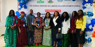 Stakeholders from Oxfam, the Federal Ministry of Labour and Employment (FMLE), and the International Labour Organization (ILO) posing together on stage at the National World of Work Gender Policy re-validation meeting on October 2nd, 2025.