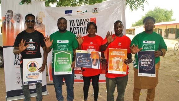 Five campaign staff holding placards with messages like "Digital Safety is a Human Right" and "Technology for Equality, Not for Abuse."