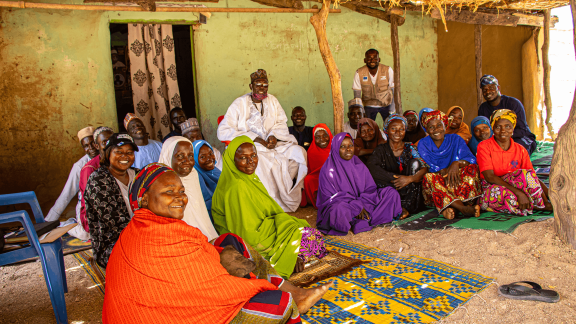 Kubuku Ward community members participating in joint planning sessions to restore shared trade routes and dissolve historical borders.