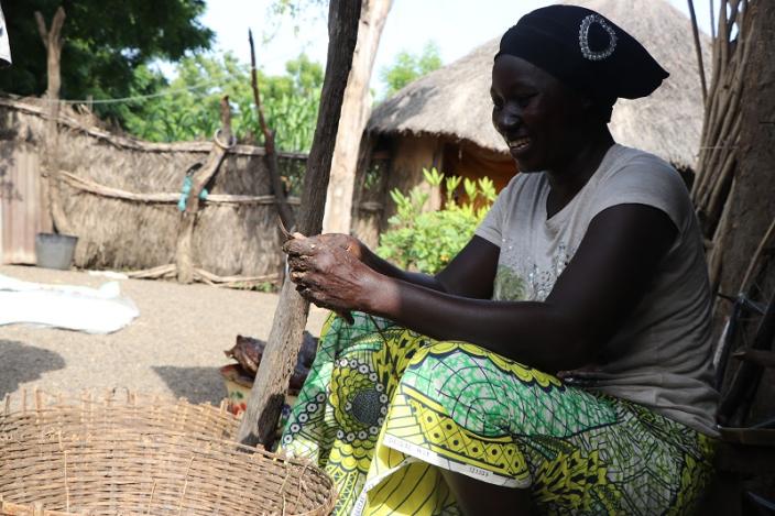 A female small scale farmer processing her farm yield