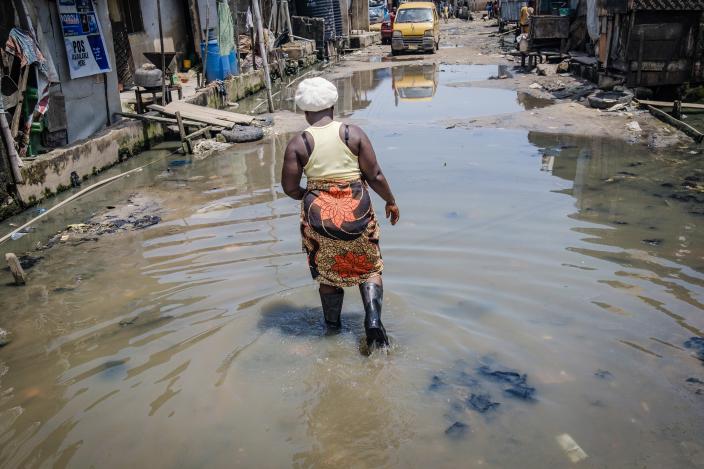 Woman walking through a flooded street in Lagos Nigeria