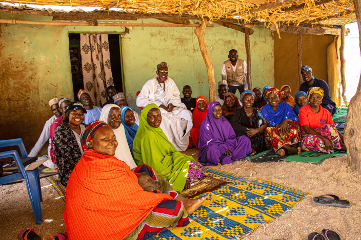 Kubuku Ward community members participating in joint planning sessions to restore shared trade routes and dissolve historical borders.