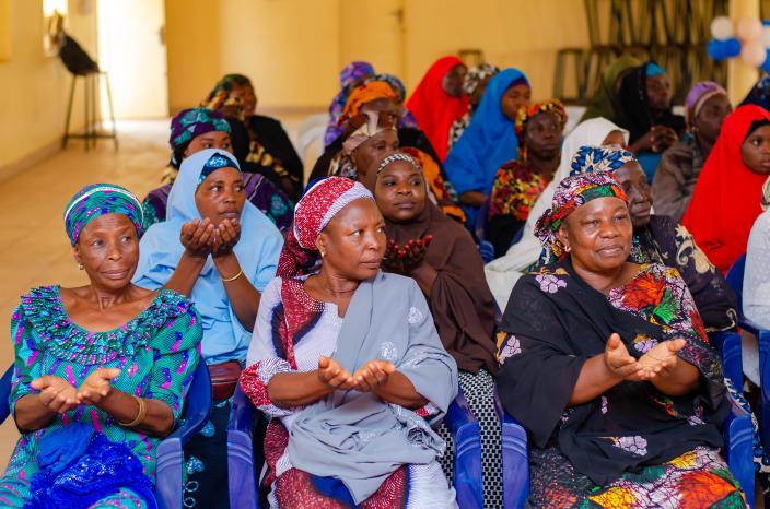 Local women in Biu holding their hands open in a gesture of solidarity, demanding rights and justice during the International Women's Day 2026 interactive sessions.
