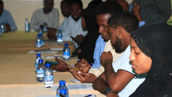 People gathered around a table, practicing digital skills as part of a training held by SONSA.