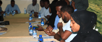 People gathered around a table, practicing digital skills as part of a training held by SONSA.