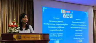 A woman speaks to an audience in front of a presentation screen at an event held by the CCC.