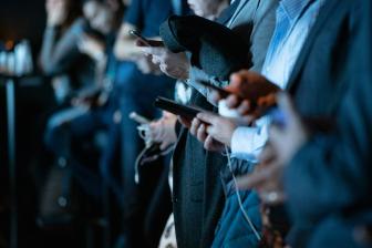 Close-up image of people holding phones.