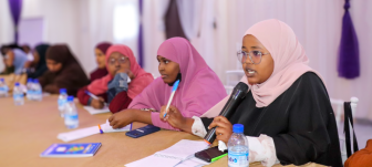Young women - members of SONSA - speak at an event.