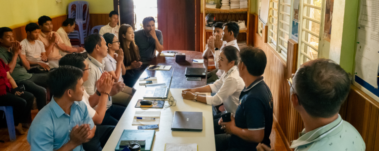 A group of people gathered around a table for a digital rights training in Cambodia.