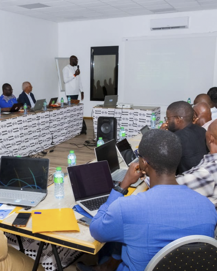 People with laptops are gathered in a room listening to a training on digital rights/skills in Senegal.