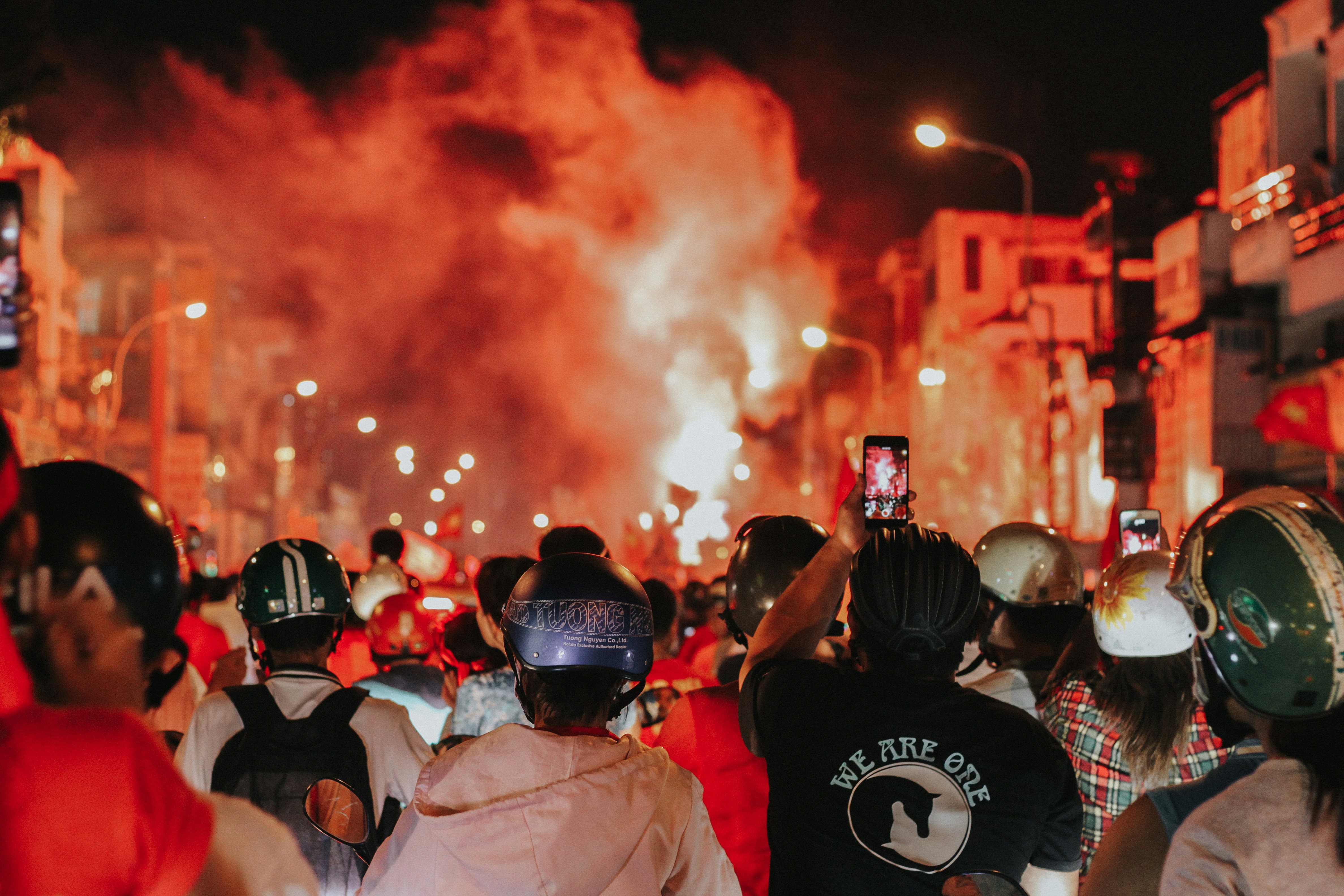image of a crowd at a protest. A few individuals are recording footage on their phones.