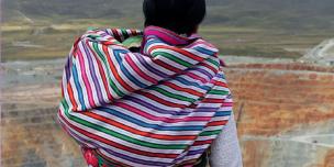 Mujer andina mirando tajo minero