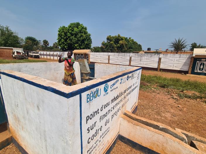 Une femme en train de puiser dans la fontaine