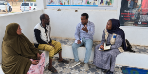 Oxfam team sitting with community members