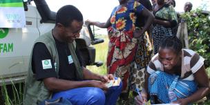 Yvonne Mweemba signing after receiving her cash as part of Oxfam and partners floods response in Zambia  Photo: Daud Kayisi/Oxfam