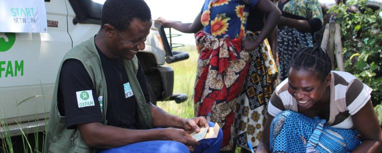Yvonne Mweemba signing after receiving her cash as part of Oxfam and partners floods response in Zambia  Photo: Daud Kayisi/Oxfam