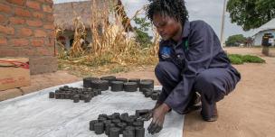 Laying out briquettes - alternatives to charcoal - to dry. Photo credit: Elizabeth Stevens/Oxfam