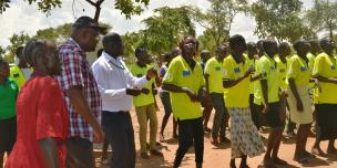 Oxfam in Uganda Country Director Peter Kamalingin joins Dynamic music group in a song on health. Photo credit: Oxfam