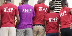 Oxfam staff pose for a photo wearing "Stop violence against women and girls'' t-shirts