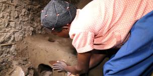 A woman constructing an energy saving stove