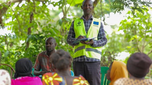 Moses meets with his savings group, where members contribute funds for disaster preparedness and response.