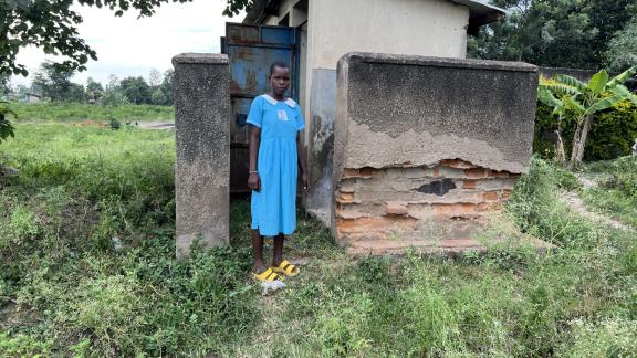 Kataike Jamira showing the nonfunctional 5 stance latrine which was formally used by Girls.jpg