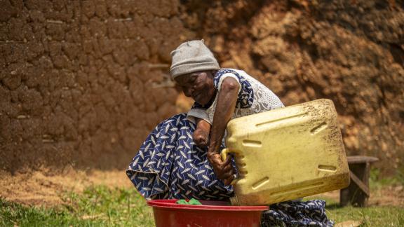 74-year-old Kabugho Sophia of Kyarumba Subcounty, a person living with a disability supported by CFA- Kasese, does her laundry with the relief item basin and jerrycan