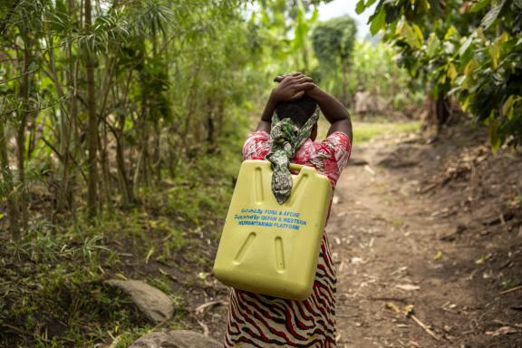 a project participant from Kyarumba subcounty ferrying water for household use using the relief jerrycan distributed by FURA