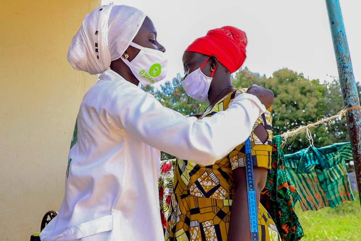 Aisha takes a customer's measurements. Photo credit: Joshua Amara/Oxfam