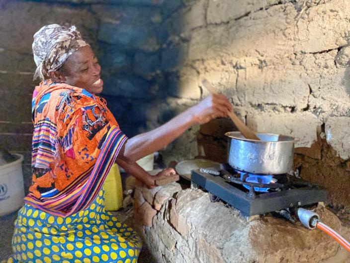 Georgette prepares a meal for her family using biogas in her kitchen