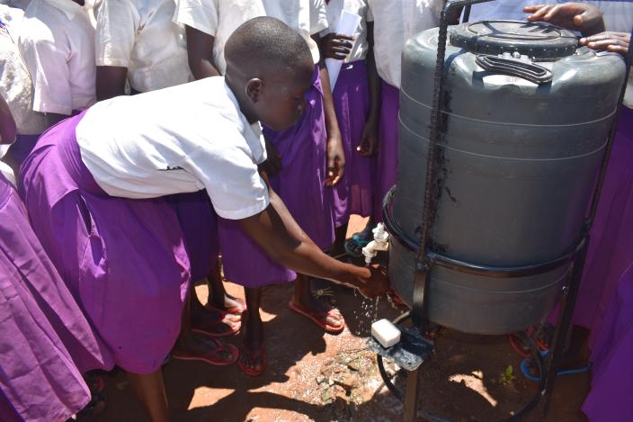 A student of Illi Primary School demonstrating proper handwashing