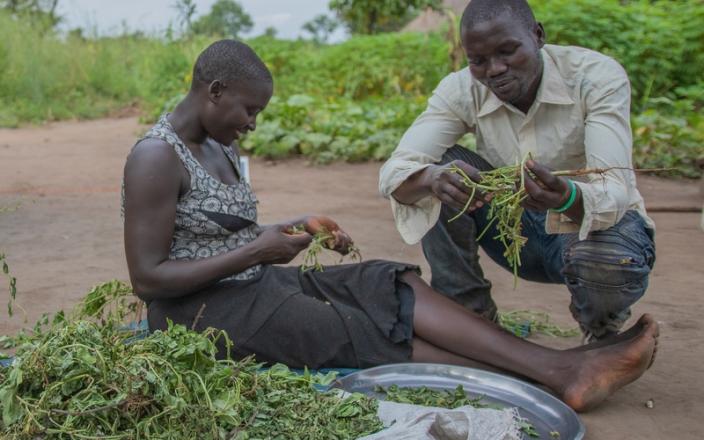 Jacki Aciro and her husband Yoweri prepare dinner together. “When your husband shares the workload with you, you feel like he cares about you,” she says. “You feel you can trust him.” Elizabeth Stevens/Oxfam