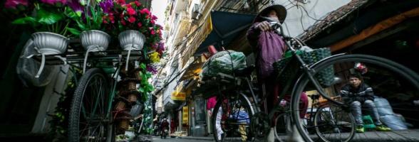 A woman cycles to work in Hanoi. Credit: Dewald Brand, Miran for Oxfam