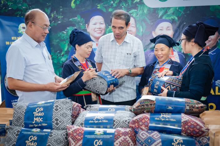 Members of Dong Tien Cooperative showing their herbal pillow to guest